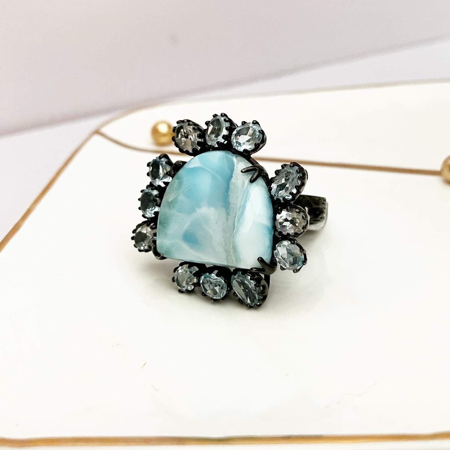 Blackened silver ring with blue agate framed with topaz.